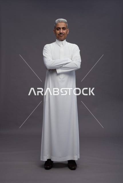 رجل سعودي بالثوب الأبيض والذراعين المتقاطعتين