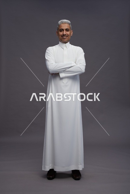 رجل سعودي بالثوب الأبيض بوضعية ذراعين متقاطعتين
