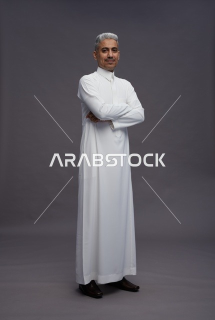 رجل سعودي بالثوب الأبيض على خلفية رمادية