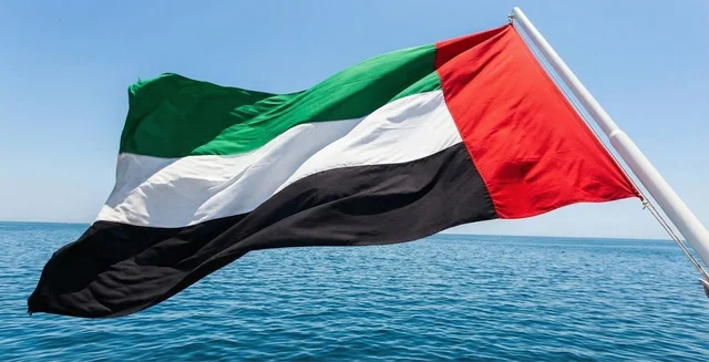 UAE Flag Waving Over Blue Sea Water