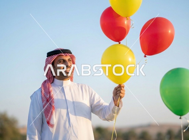 رجل سعودي مع بالونات ملونة في احتفالات العيد