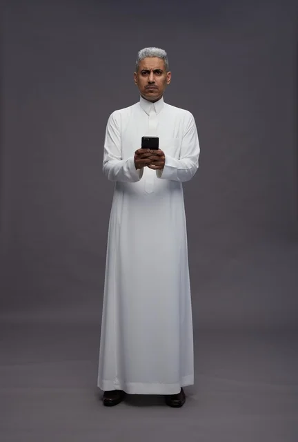 Saudi Man in Traditional Thobe Using Smartphone in Studio