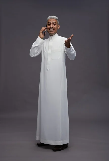 Saudi Man in White Thobe Talking on Smartphone