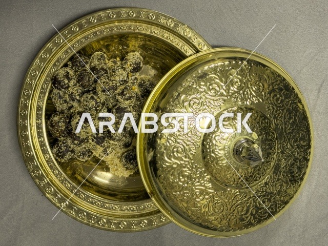 تمر مقدم في وعاء نحاسي مزخرف يعكس الضيافة العربية والتراث الثقافي الأصيل في الخليج العربي