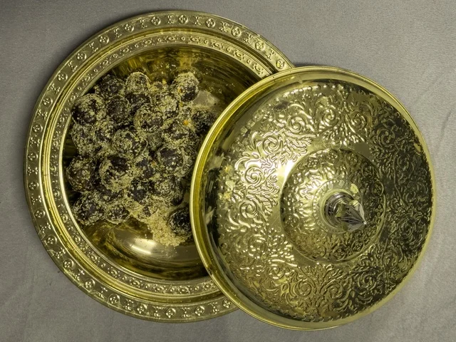 تمر مقدم في وعاء نحاسي مزخرف يعكس الضيافة العربية والتراث الثقافي الأصيل في الخليج العربي