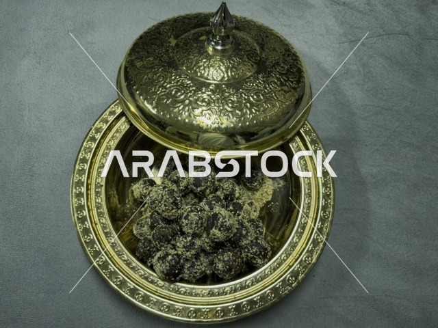 تمر مقدم في وعاء نحاسي مزخرف يعكس الضيافة العربية والتراث الثقافي الأصيل في الخليج العربي