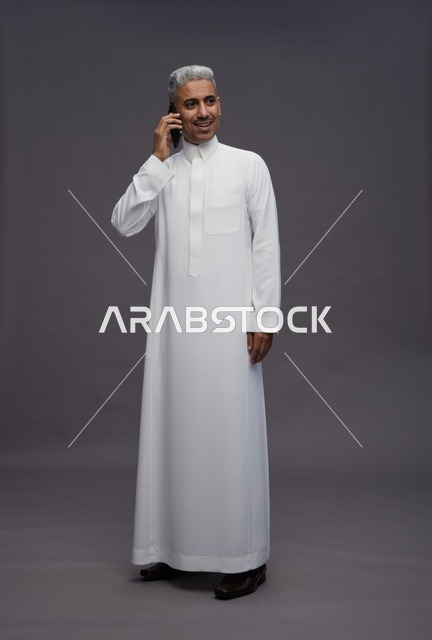 رجل سعودي بالثوب يتحدث عبر الهاتف في الاستوديو