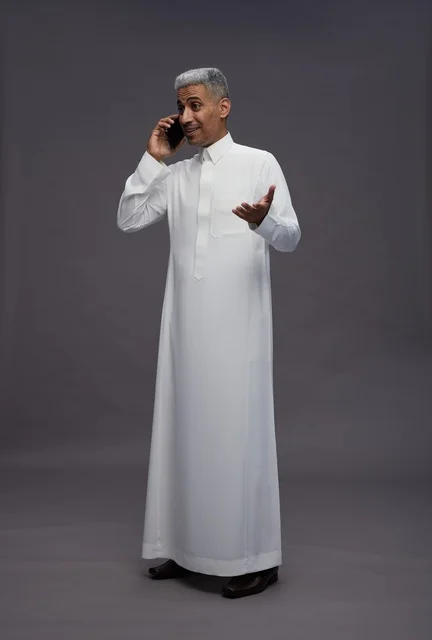 Saudi Man in Traditional Thobe Talking on Mobile Phone