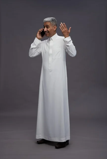 Saudi Man in White Thobe Talking on Smartphone Studio