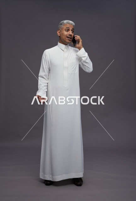 رجل سعودي بالثوب الأبيض يتحدث بالهاتف في الاستوديو