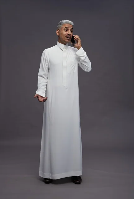رجل سعودي بالثوب الأبيض يتحدث بالهاتف في الاستوديو