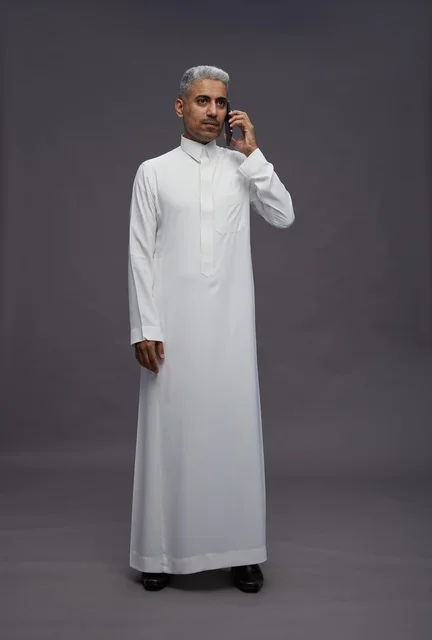 رجل سعودي بالثوب الأبيض يتحدث عبر الجوال