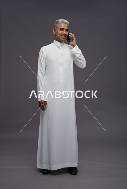 رجل سعودي بالثوب الأبيض يتحدث بالجوال
