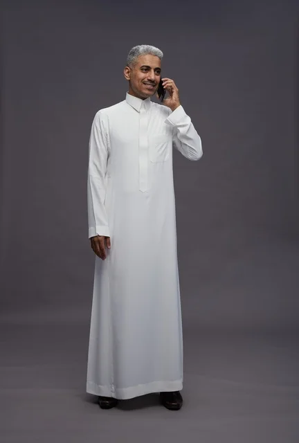 رجل سعودي بالثوب الأبيض يتحدث بالجوال