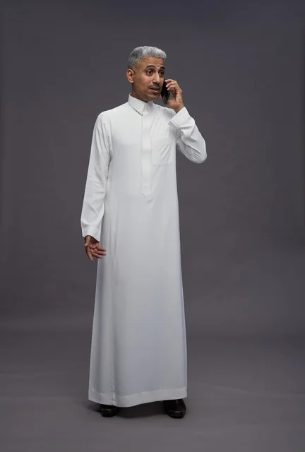 رجل سعودي بالثوب الأبيض يتحدث في الجوال
