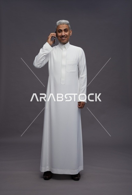 رجل سعودي بالثوب الأبيض يتحدث عبر الجوال