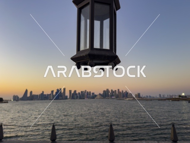 فانوس تقليدي أمام أفق مدينة الدوحة وقت الغروب