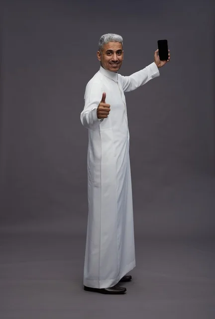 رجل سعودي بالثوب يحمل هاتف ذكي مع إشارة موافقة