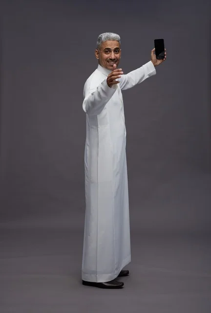 رجل سعودي بالثوب التقليدي يلتقط سيلفي بالهاتف