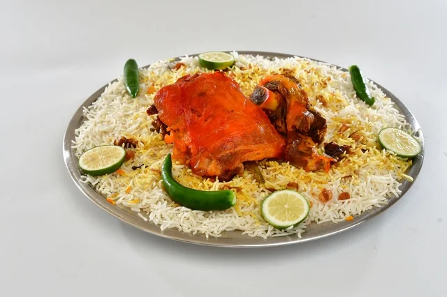 A plate of Saudi Mandi rice with roasted chicken, traditional white popular rice, traditional Saudi popular restaurant, white background.