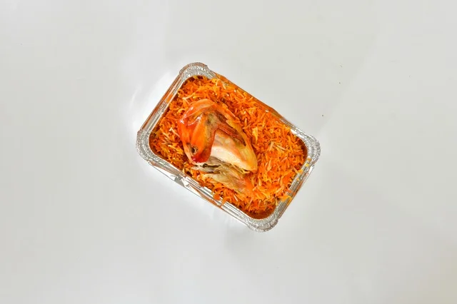 طبق من الرز المندي الاحمر السعودي مع الدجاج المحمر , أرز شعبي باللون البرتقالي , مطعم سعودي شعبي تقليدي, خلفيه بيضاء