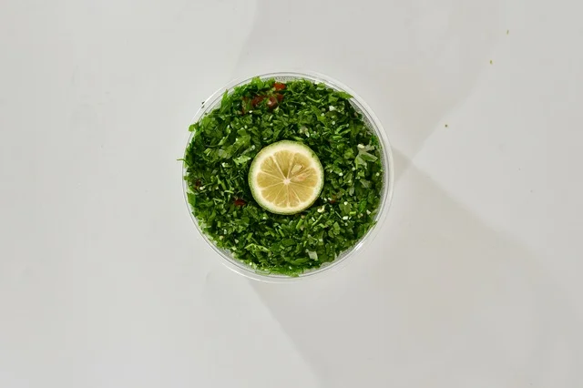 صوره علويه عاموديه لطبق من التبوله الخضراء , سلطة صحيه بالبقدونس , مطعم سعودي شعبي تقليدي, خلفيه بيضاء