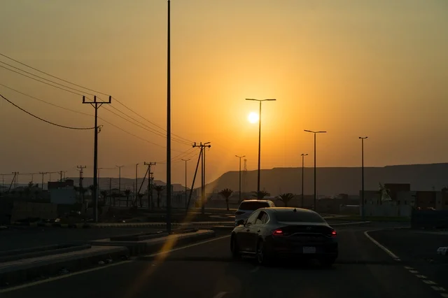 The view of the sunset at the Arabic coffee roundabout with coffee cups in the village of Mudrikah on the road to Jeddah in Mecca, a historic popular area, with mountainous terrain and paved roads in the city, Kingdom of Saudi Arabia.