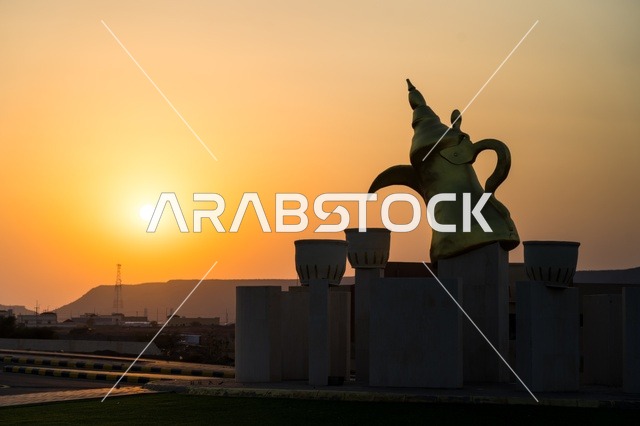 منظر غروب الشمس عند دوار الدله العربيه  مع فناجين القهوه في قرية مدركه على طريق جده في مكه المكرمه, منطقه شعبيه تاريخيه قديمه, التضاريس الجبليه والطرق المعبده  في المدينه, المملكه العربيه السعوديه