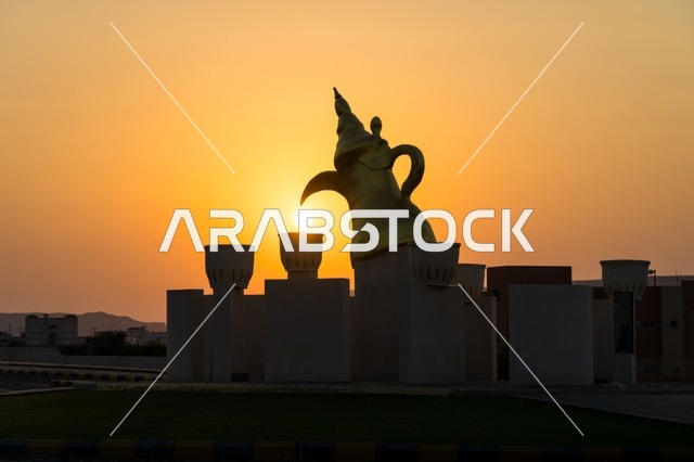 منظر غروب الشمس عند دوار الدله العربيه  مع فناجين القهوه في قرية مدركه على طريق جده في مكه المكرمه, منطقه شعبيه تاريخيه قديمه, التضاريس الجبليه والطرق المعبده  في المدينه, المملكه العربيه السعوديه