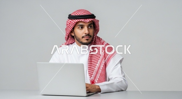 Focused Saudi man working on his laptop and thinking