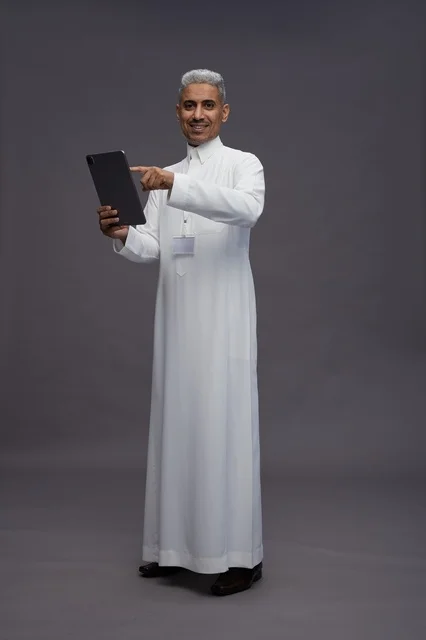 بورتريه لرجل عربي سعودي خليجي يرتدي الثوب الابيض يحمل بيده جهاز التابليت المحمول, ايماءات وتعابير مختلفه, كامل الجسم, خلفيه رماديه بورتريه لرجل عربي سعودي خليجي يرتدي الثوب الابيض يحمل بيده جهاز التابليت المحمول, ايماءات وتعابير مختلفه, كامل الجسم, خلفيه رماديه