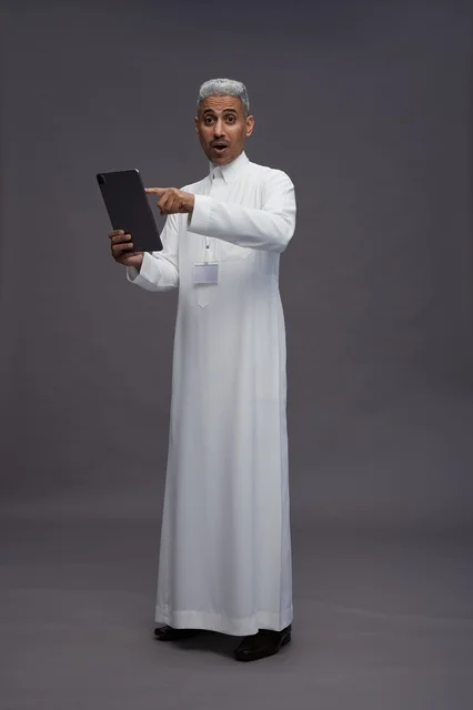 A portrait of an Arab Saudi Gulf man wearing a white thobe holding a mobile tablet in his hand, with various gestures and expressions, full body, gray background. A portrait of an Arab Saudi Gulf man wearing a white thobe holding a mobile tablet in his hand, with various gestures and expressions, full body, gray background.