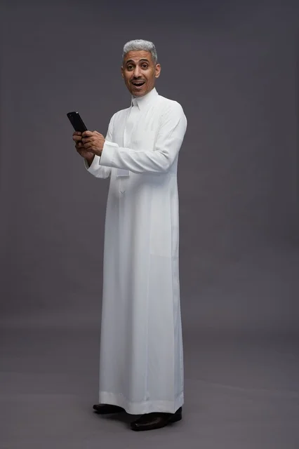 A portrait of an Arab Saudi Gulf man wearing a white thobe using a mobile phone, with various gestures and expressions, full body, gray background.