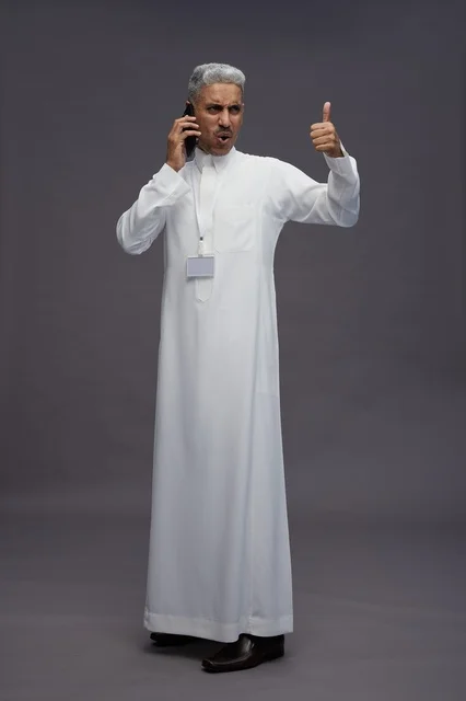 A portrait of an Arab Saudi Gulf man wearing a white thobe using a mobile phone, with various gestures and expressions, full body, gray background.