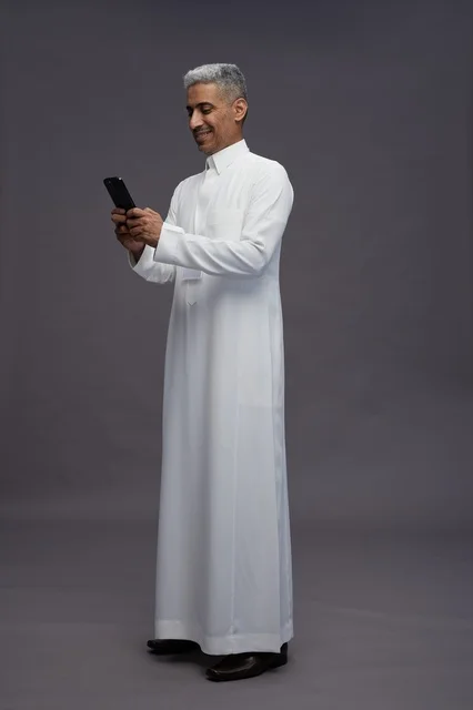 A portrait of an Arab Saudi Gulf man wearing a white thobe using a mobile phone, with various gestures and expressions, full body, gray background.