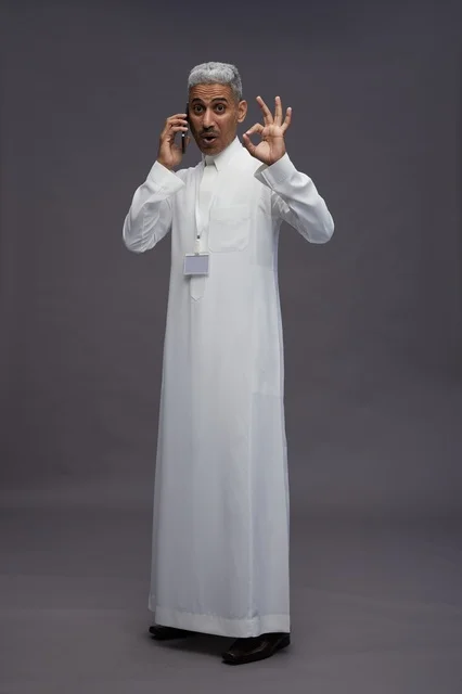 A portrait of an Arab Saudi Gulf man wearing a white thobe using a mobile phone, with various gestures and expressions, full body, gray background.