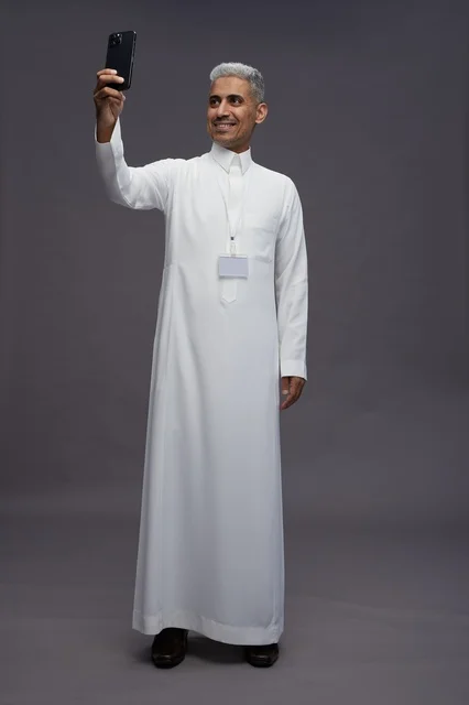 A portrait of an Arab Saudi Gulf man wearing a white thobe using a mobile phone, with various gestures and expressions, full body, gray background.