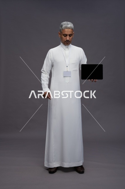 Saudi professional holding blank tablet screen