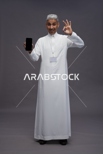 رجل سعودي يعرض شاشة هاتف ذكي فارغة