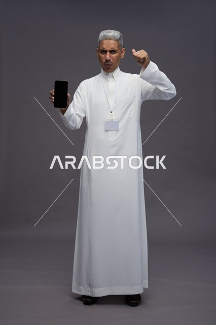 رجل سعودي يعرض شاشة هاتف ذكي فارغة