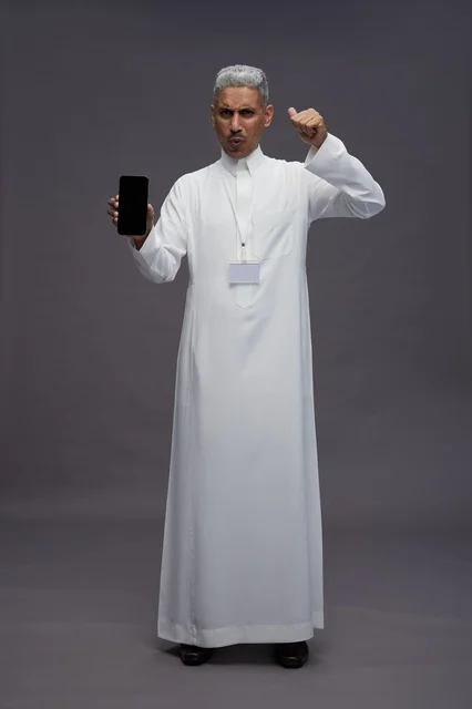 رجل سعودي يعرض شاشة هاتف ذكي فارغة