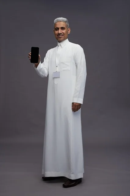 رجل سعودي يعرض شاشة هاتف ذكي فارغة