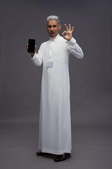 رجل سعودي يعرض شاشة هاتف ذكي فارغة