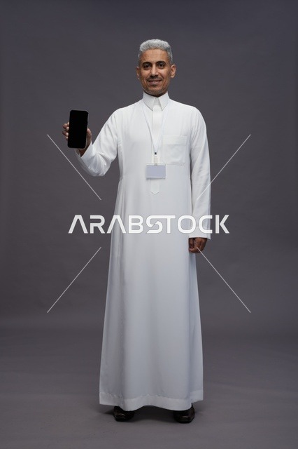 رجل سعودي يعرض شاشة هاتف ذكي فارغة