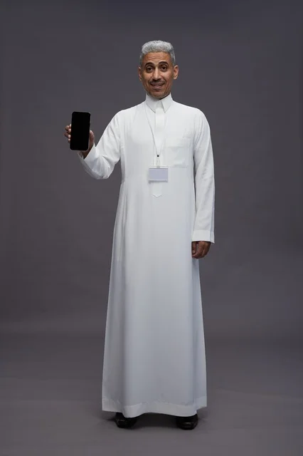 رجل سعودي يعرض شاشة هاتف ذكي فارغة