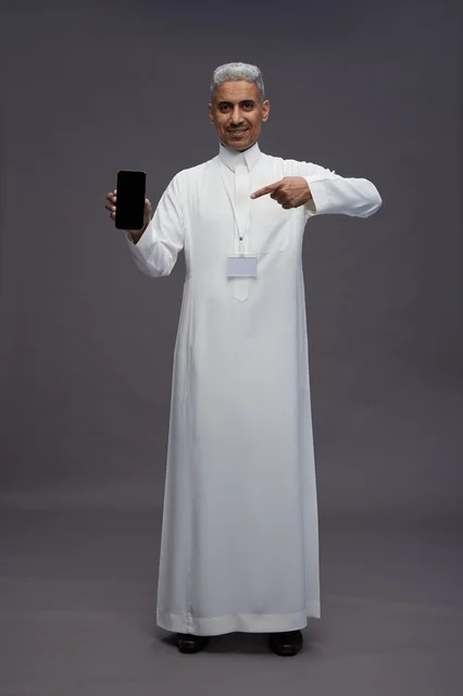 رجل سعودي يعرض شاشة هاتف ذكي فارغة