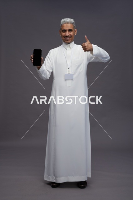 رجل سعودي يعرض شاشة هاتف ذكي فارغة