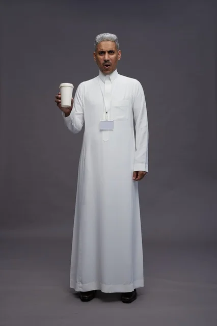 A portrait of an Arab Saudi Gulf man wearing a white thobe and enjoying drinking coffee, with a gray background, full body.