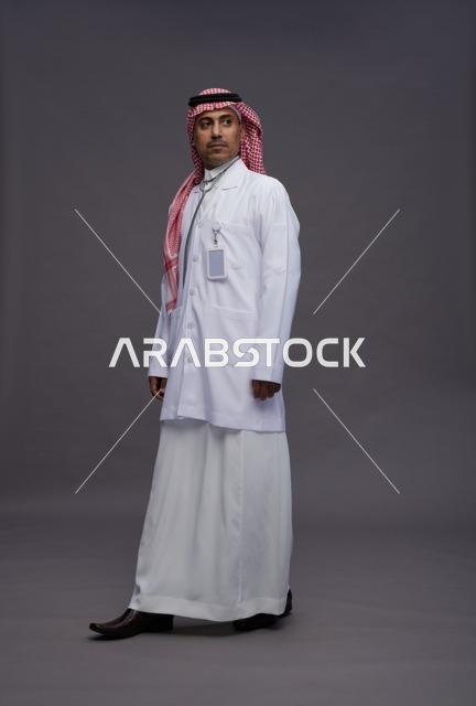 طبيب عربي سعودي خليجي يرتدي الثوب والمعطف الابيض مع سماعة الطب يقوم بايماءات واشارات مختلفه, كامل الجسم, خلفيه رماديه