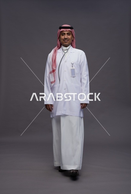طبيب عربي سعودي خليجي يرتدي الثوب والمعطف الابيض مع سماعة الطب يقوم بايماءات واشارات مختلفه, كامل الجسم, خلفيه رماديه